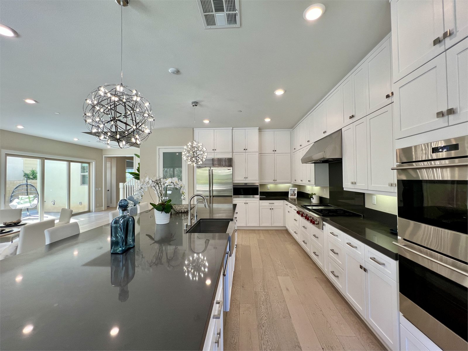 Finished kitchen with white cabinets, black countertops, and a central island
