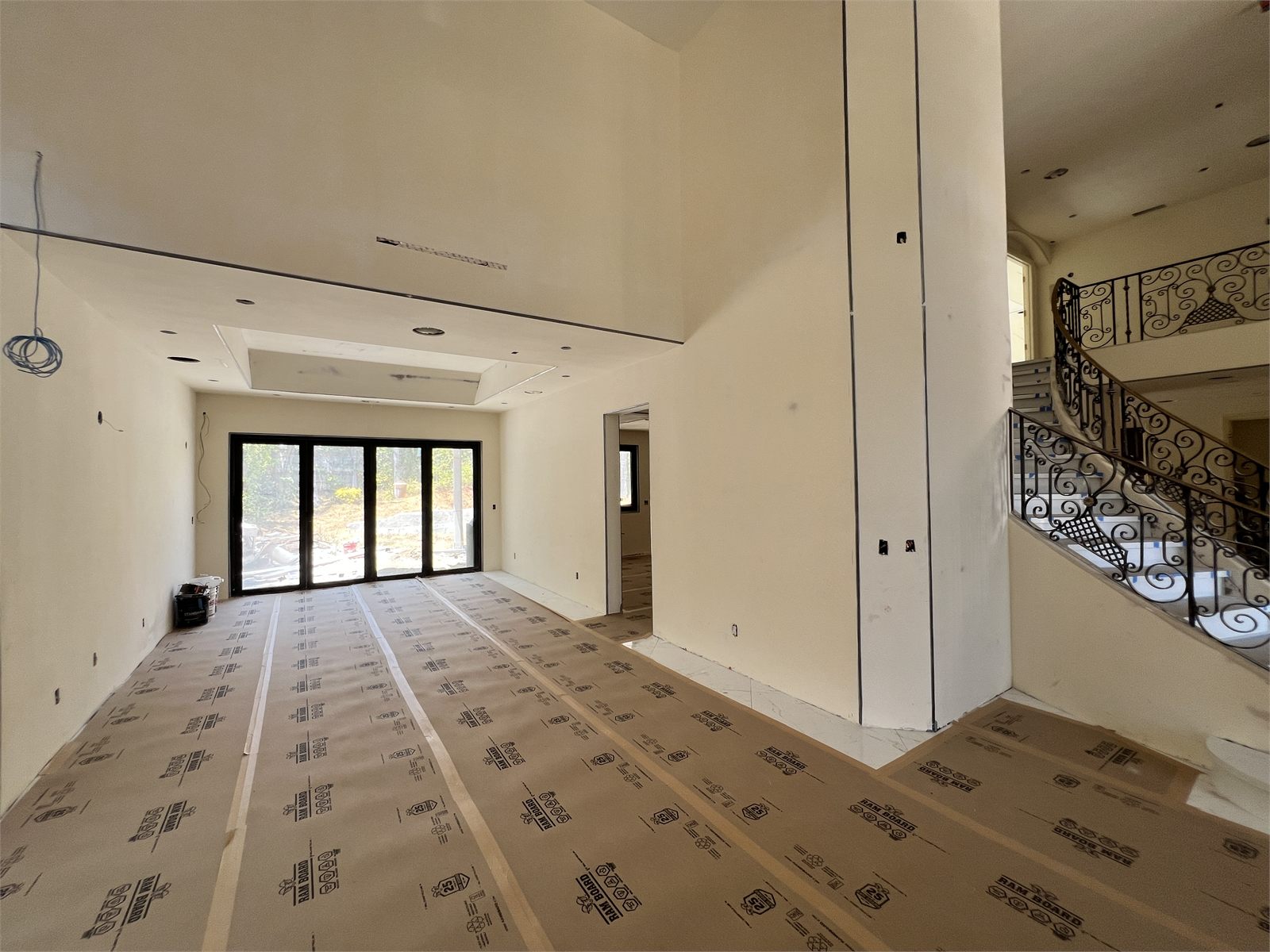 Double-exposure image showing a two-story home during framing, overlaid with its finished kitchen island